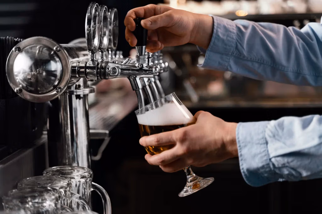 Close up hands pouring beer glass
