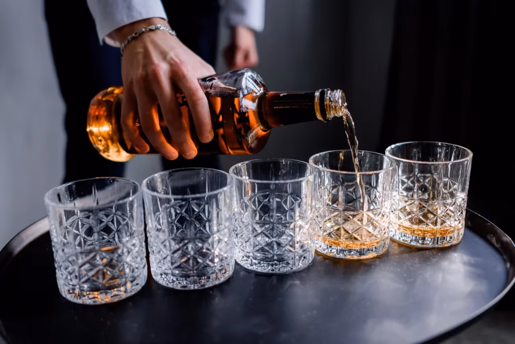 Man pouring rum into glass