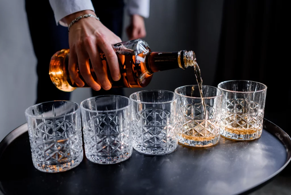 Man pouring rum into glass